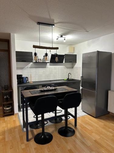 Apartment „Slow Horses“ في لايبزيغ: مطبخ مع طاولة وكراسي وثلاجة
