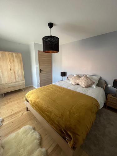 - une chambre avec un grand lit et une couverture en or dans l'établissement Charmant appartement avec vue sur les vignes, à Lussac