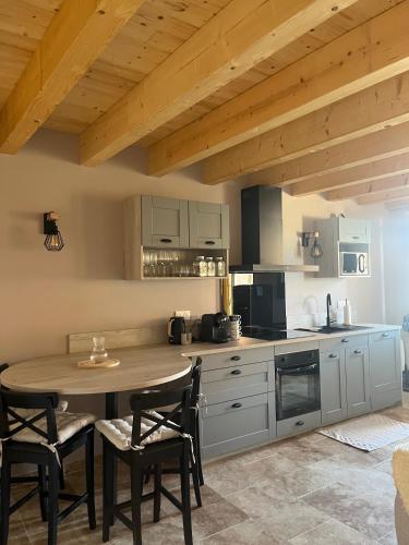 une cuisine avec une table et des chaises dans une pièce dans l'établissement Charmant appartement avec vue sur les vignes, à Lussac