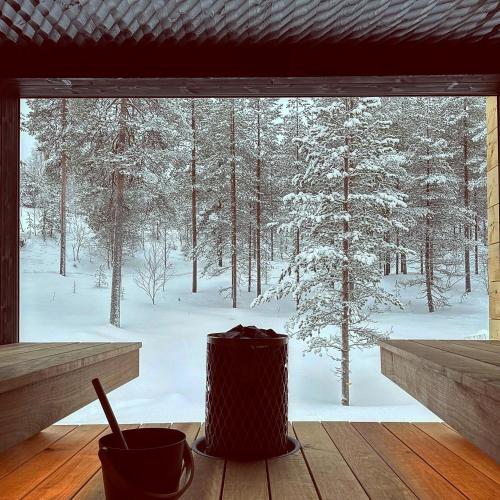 a window with a view of a snow covered forest at Kimmelvilla Pyhä - Ski-in, modern design and spectacular scenery in Pyhätunturi