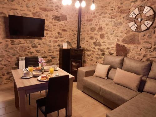 a living room with a table and a couch at El Regueron in Folgoso de la Ribera