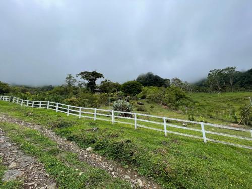 a white fence on the side of a field at Rinconcito de Paz, Cedral, Pérez Zeledón in Cedral