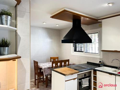 a kitchen with a stove top oven next to a table at La Villa in Benicàssim