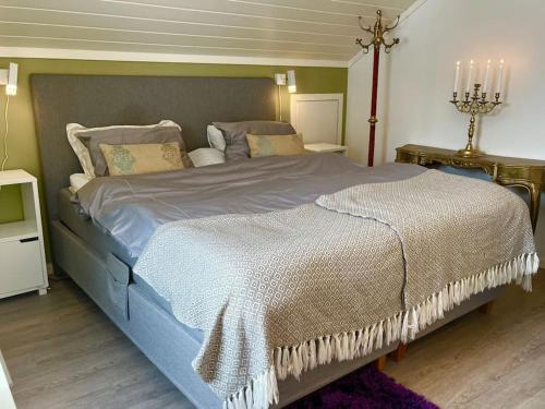 um quarto com uma cama grande e um edredão azul em Villa by the sea, close to the city, with panoramic views em Bergen