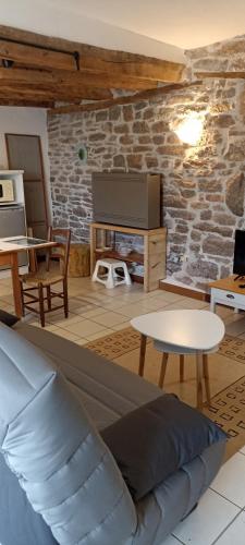 a living room with a couch and a table at Les gites et chambres d'hôtes du Mas de bouzou in Grèzes