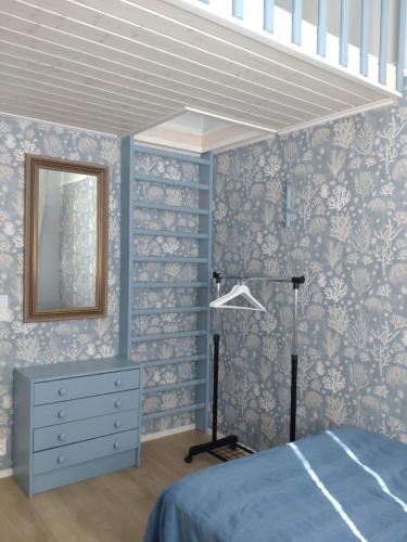 a bedroom with a bed and a dresser and a mirror at Summer Home in Muuruvesi