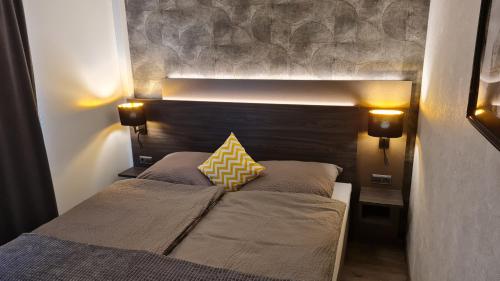 1 dormitorio con 1 cama con cabecero de madera en Lins B&B Hotel Resort en Marktlustenau