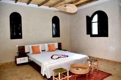 um quarto com uma cama com 2 cadeiras e uma mesa em Villa sur Colline son vis-à-vis em Marrakech