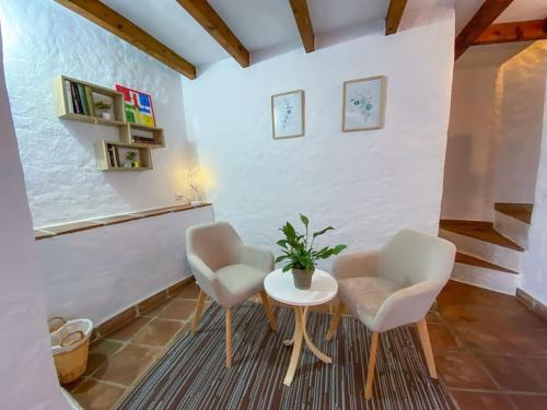 a living room with two chairs and a table at CasaBenadalid. Casa rural con piscina. in Benadalid