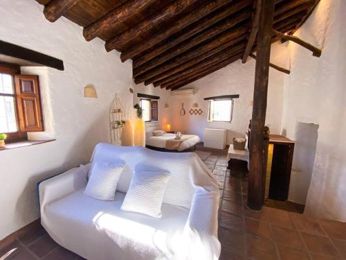 Tempat tidur dalam kamar di CasaBenadalid. Casa rural con piscina.