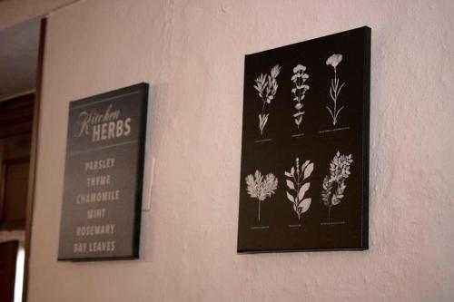 two pictures of flowers are hanging on a wall at CasaBenadalid. Casa rural con piscina. in Benadalid