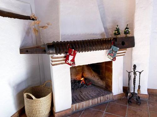 a fireplace with christmas ornaments on top of it at CasaBenadalid. Casa rural con piscina. in Benadalid