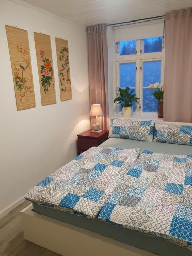a bedroom with a bed with a quilt on it at Sonnige Ferienwohnung I in Harrislee