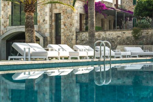a swimming pool with white lounge chairs next to a building at Monnàber Vell in Campanet