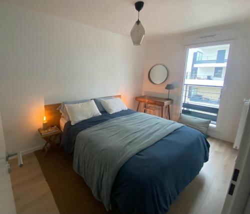 une chambre avec un grand lit et une fenêtre dans l'établissement Duplex terrasse à Clichy, Hauts de Seine, à Clichy