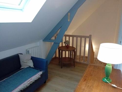 a living room with a blue couch and a table at Gite Ferme du Marronnier in Graincourt