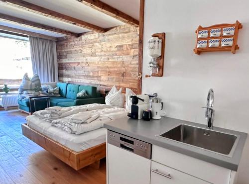 a kitchen with a bed in the middle of a room at Stylisches Chalet im Schlosspark Grubhof mit Innenpool und Balkon in Sankt Martin bei Lofer