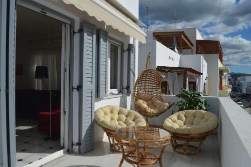 a patio with two chairs and a table on a balcony at Althea Old Town Apartment in Naxos Chora