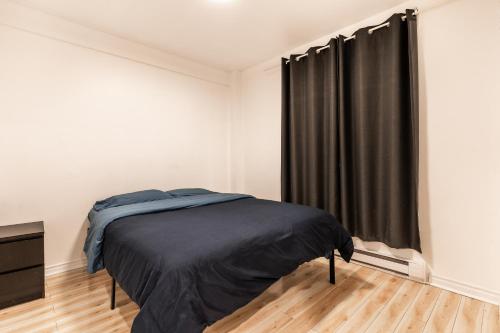 1 dormitorio con cama y cortina negra en Cozy 1 bedroom apartment - 107, en Montreal