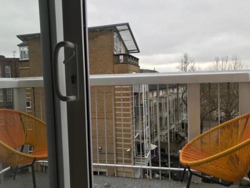 two chairs sitting on a balcony looking out a window at En-suite room with a superking size bed and balcony in London