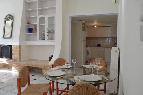 a dining room and kitchen with a glass table and chairs at Althea Old Town Apartment in Naxos Chora