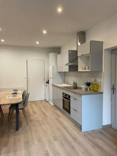 une cuisine avec une table et une salle à manger dans l'établissement Appartement neuf & moderne Orgelet: confort assuré, à Orgelet