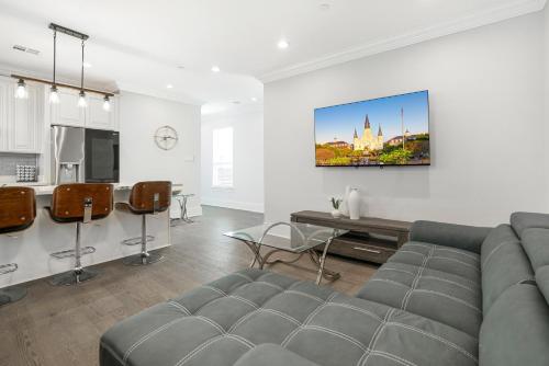 a living room with a gray couch and a kitchen at New 3-Bed Luxury House in New Orleans