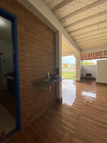 Habitación con pared de madera y lavabo. en Casa 2 Quartos 2 Suítes Castelhanos ES, en Anchieta