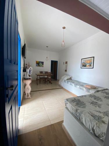 a bedroom with a bed and a dining room at Casa 2 Quartos 2 Suítes Castelhanos ES in Anchieta