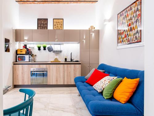 sala de estar con sofá azul y cocina en Cavour central apartment, en Turín