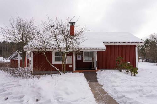 a small red house with snow on the ground at Mökki luonnon keskellä Espoossa in Espoo