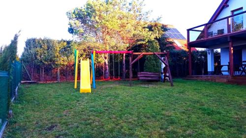 a playground in a yard next to a house at Dom z pięknymi widokami na jezioro ryńskie ilasy. in Rybical