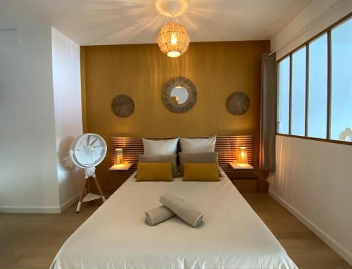 - une chambre avec un lit avec deux oreillers et un ventilateur dans l'établissement Le Perchoir du lac ~ Vue plongeante Lac & Montagne, à Tresserves