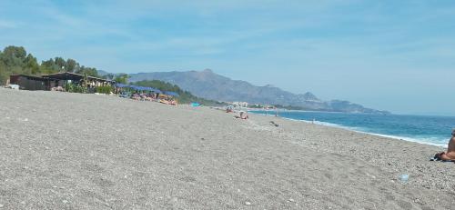 a group of people on a beach near the water at Home Tropicana in Mascali