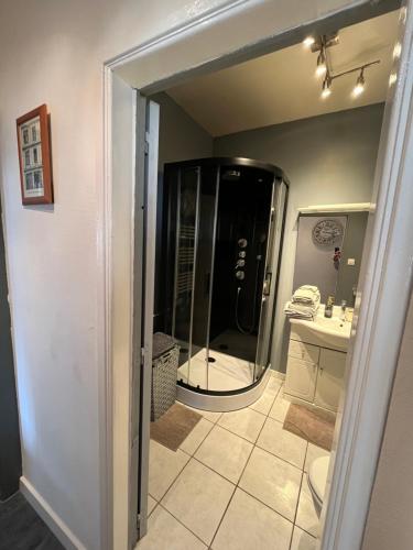 ein Bad mit einer Dusche, einem Waschbecken und einem Spiegel in der Unterkunft Maison Jehan-Séré in Tarascon-sur-Ariège