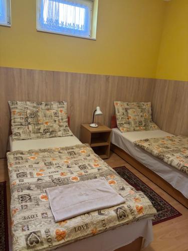 a room with two beds and a table and a window at Horvath Vendeghaz in Hegyeshalom