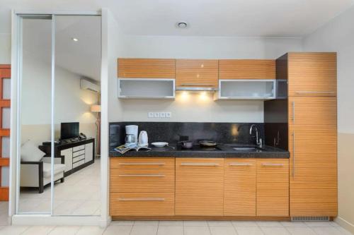 une cuisine avec des armoires en bois et un évier dans l'établissement Studio centre-ville proche Gare SNCF, à Cannes