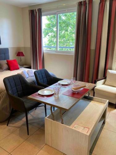 un salon avec une table et un lit dans l'établissement Studio centre-ville proche Gare SNCF, à Cannes