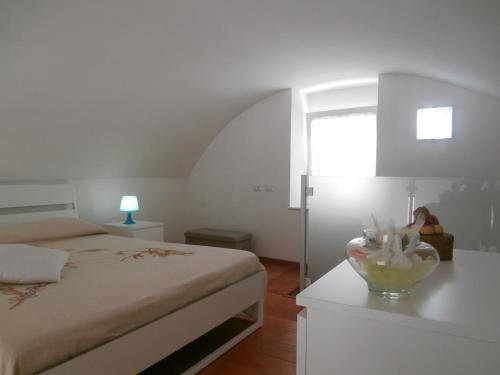 Un dormitorio con una cama y un tazón de flores en un mostrador en Casa Vacanza Martino en Matera