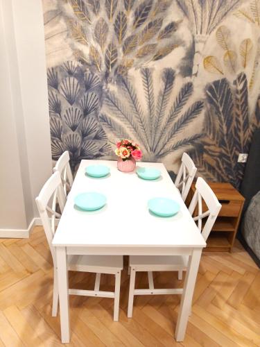 a white table with four chairs in a room at Apartament Marzenie 1 i 2 by Apartamenty na dni Wrocław in Wrocław