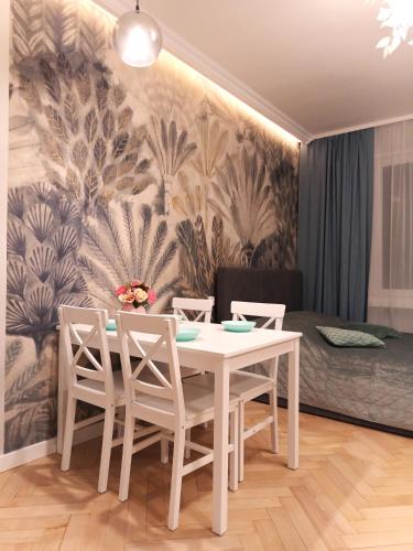 a dining room with a white table and chairs at Apartament Marzenie 1 i 2 by Apartamenty na dni Wrocław in Wrocław