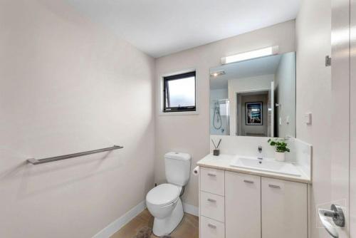 a white bathroom with a toilet and a sink at Room to rent at the Glasshouse Mountains - Wifi in Brisbane