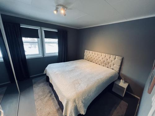 1 dormitorio con 1 cama y 2 ventanas en Stort og flott hus på Tyholt, en Trondheim