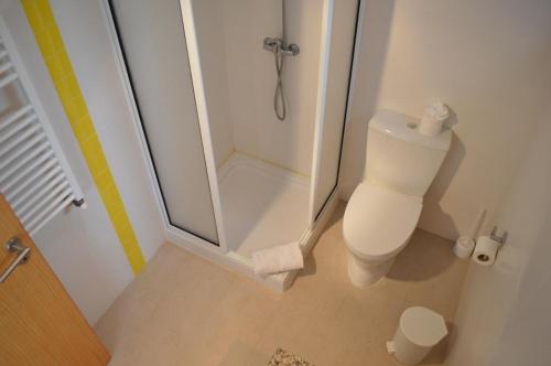 a white bathroom with a shower and a toilet at Foz Ocean Retreat in Foz do Arelho
