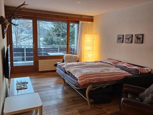 um quarto com uma cama e uma janela em Sonnenzauber em Andermatt