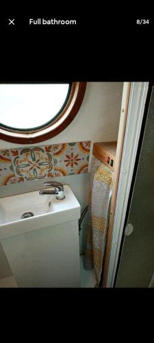 a bathroom with a sink and a window at Cosy, secluded narrow boat in Airton