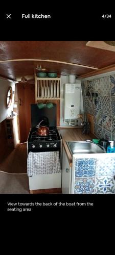 a small kitchen with a stove and a sink at Cosy, secluded narrow boat in Airton