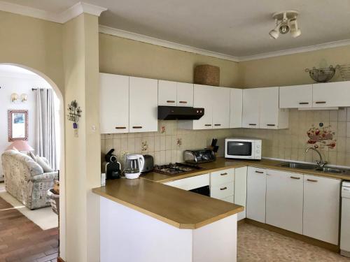 a kitchen with white cabinets and a counter top at Above the Sea in Fish hoek