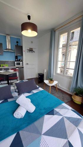 une chambre avec un grand lit avec des serviettes dessus dans l'établissement L'Ancre du port, à Dieppe