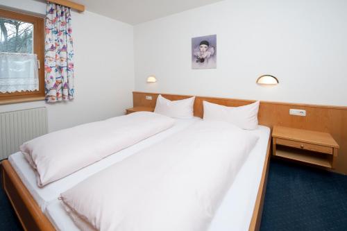 1 dormitorio con 1 cama con sábanas blancas y ventana en Landhaus Schiestl, en Fulpmes